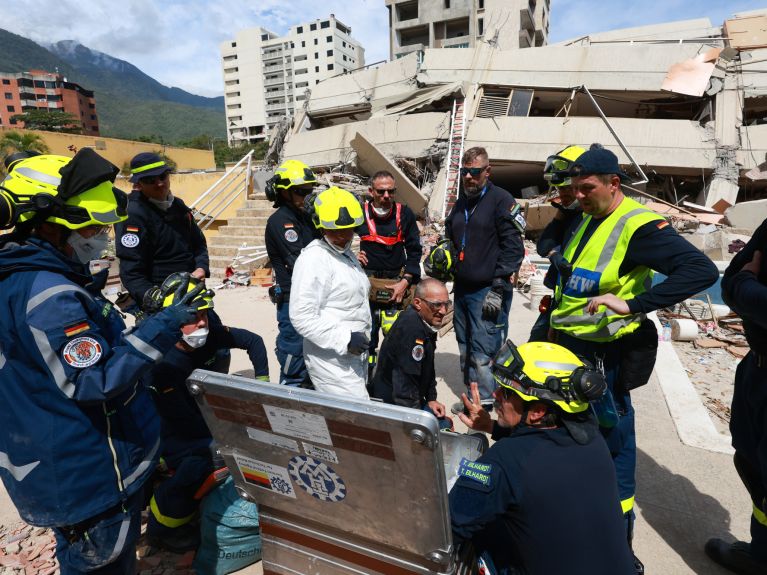 Varias personas con equipo de protección de la THW se consultan entre sí.