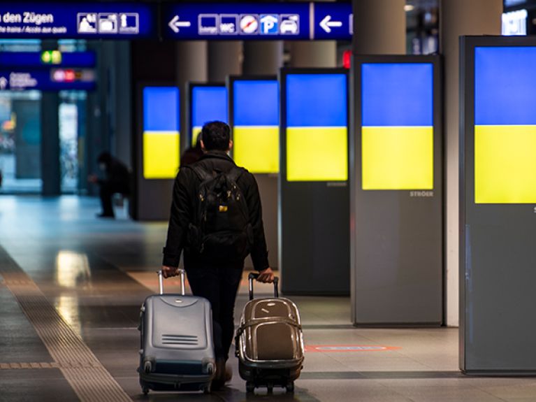 In Berlin's main railway station, the colours of the Ukrainian national flag are displayed on advertising monitors.