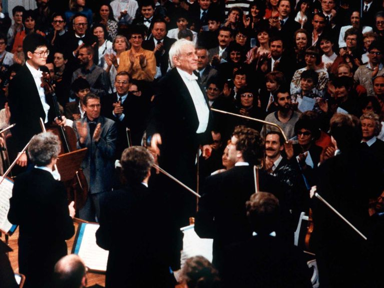Leonard Bernstein is applaused after conducting an international ensemble during the East-West-Concert shortly after the Berlin wall came down in Berlin, 25 December 1989.