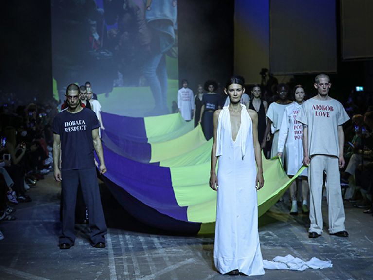 At this year's Berlin Fashion Week, designers and the public show their solidarity with Ukraine. Here, models present creations by Ukrainian designer Jean Gritsfeldt, carrying a Ukrainian flag.