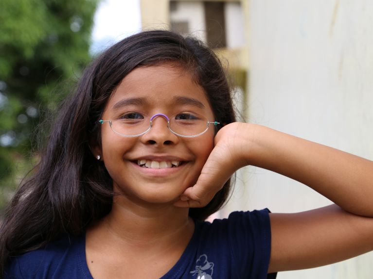 Lernen und Ausbildung hängen extrem von der Sehfähigkeit – fröhliche Schülerin in Brasilien. 