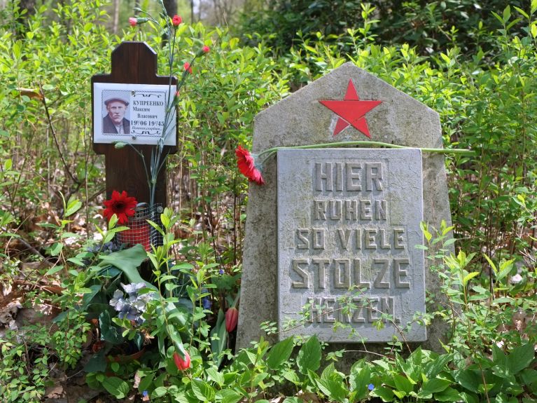 Gäste gedenken mit Blumen an die Opfer   