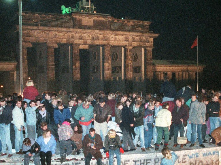 Berliner feiern und tanzen auf der Mauer, 1989