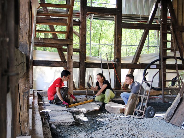 Preservar o patrimônio cultural. Um grupo de voluntários internacionais trabalhando.