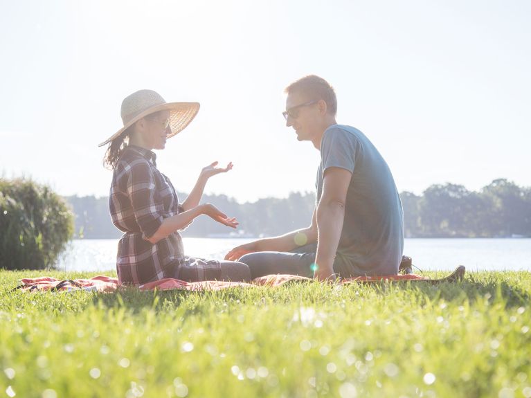 Frau und Mann beim Picknick am See