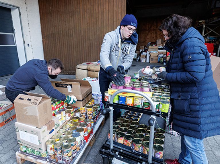 Helpers pack a europallet with food for an aid transport. The relief supplies are driven by lorries to the Polish-Ukrainian border.