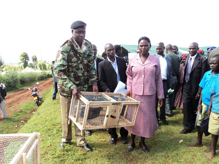 One hen campaign project kenya presenting a hen to beneficiary