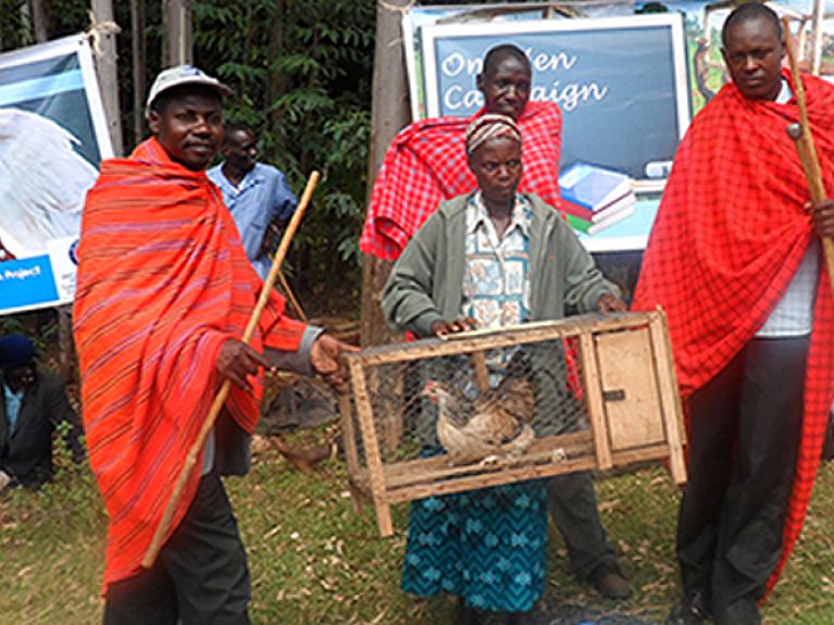 One hen campaign project kenya presenting a hen to beneficiary