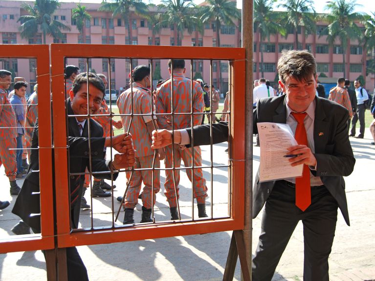 Jochen Weikert (à droite) et un collègue de la GIZ remettent un équipement aux pompiers à Dacca.