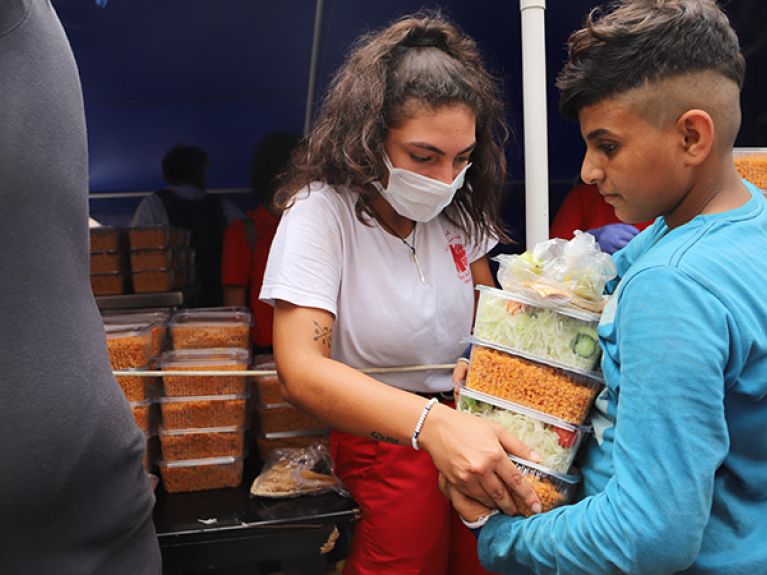   Helfer verteilen Essen an die Menschen auf der Straße.