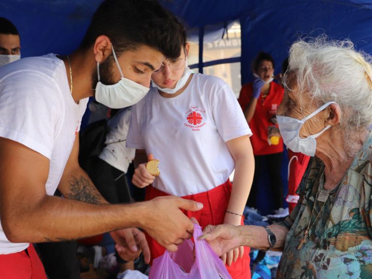 Helfer der Caritas geben Essen in Beirut aus.