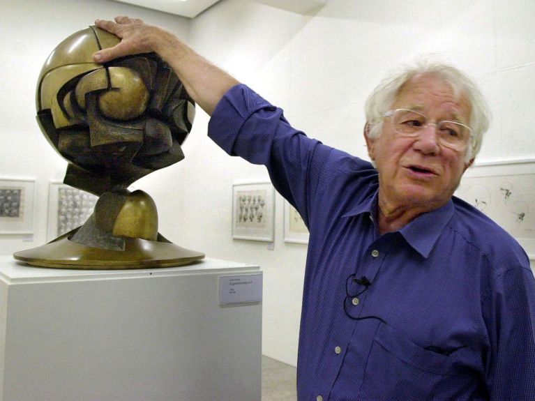 Fritz Koenig in front of a model of his most famous work in 2002