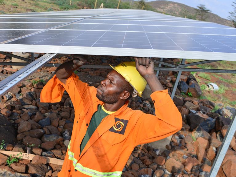 Un technicien en train de poser des panneaux solaires