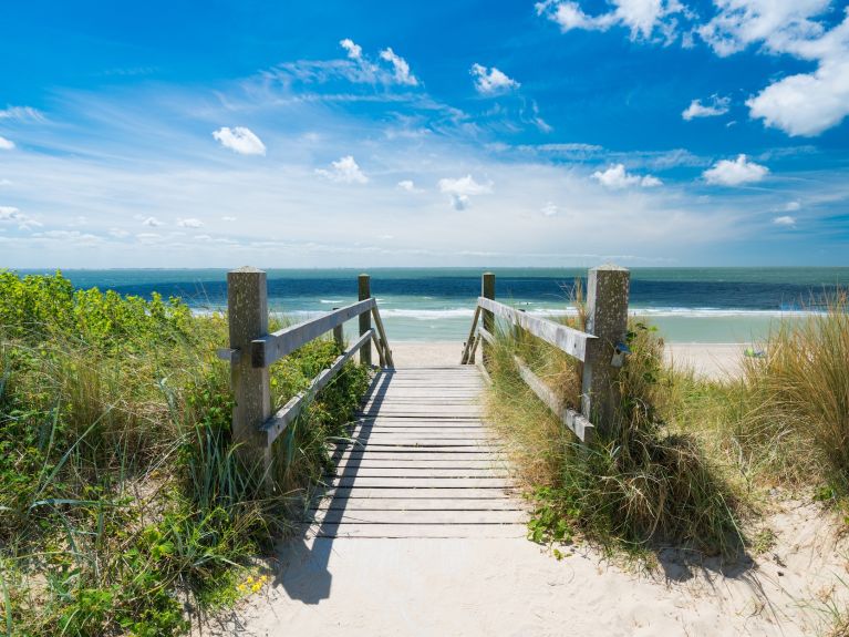 Strandzugang mit Blick aufs Meer und Dünen.