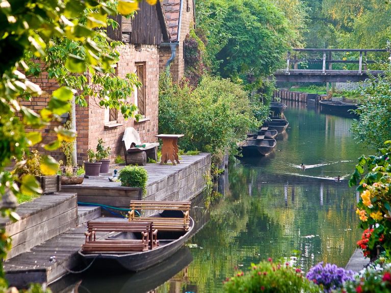 Ein Fluss mit Booten und einem Haus am Ufer.