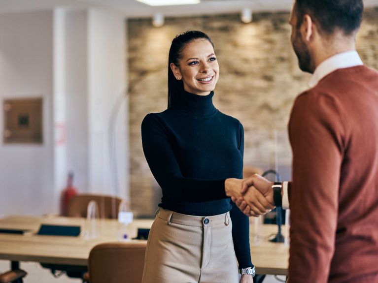 Business partners shaking hands after the meeting, male and female.