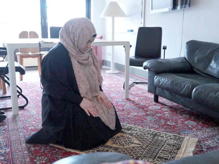 Feyza nutzt einen Gemeinschaftsraum im Büro zum Gebet