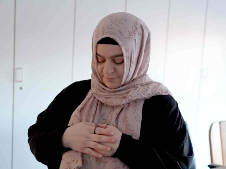 Feyza nutzt einen Gemeinschaftsraum im Büro zum Gebet