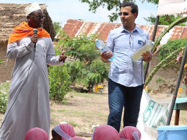 Hamed Beheshti zeigt den Unterschied zwischen ungefiltertem Wasser und Trinkwasser in Kenia.