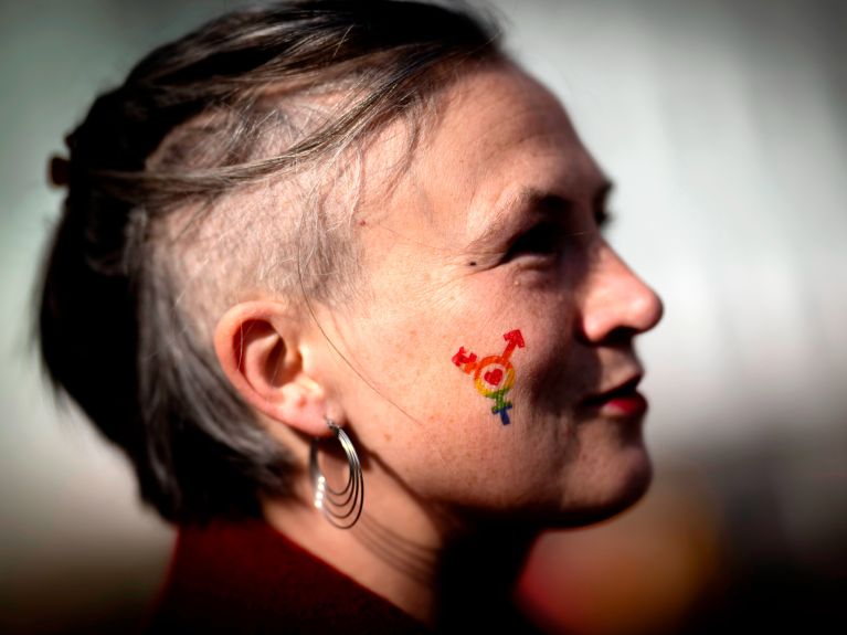Klare Haltung: Eine Demonstrantin trägt das Symbol für geschlechtliche Vielfalt auf der Wange. 