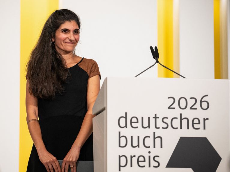 Autorin Shida Bazyar steht neben einem Redepult.