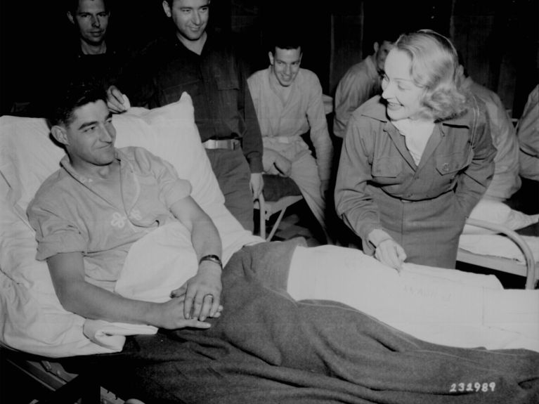 „Die Dietrich“ unterschreibt den Gips eines GI. „Die Dietrich“ unterschreibt den Gips eines GI.