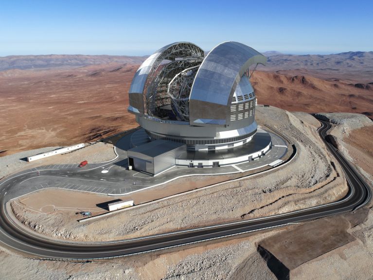 Modell eines Teleskops in sandigem Gelände