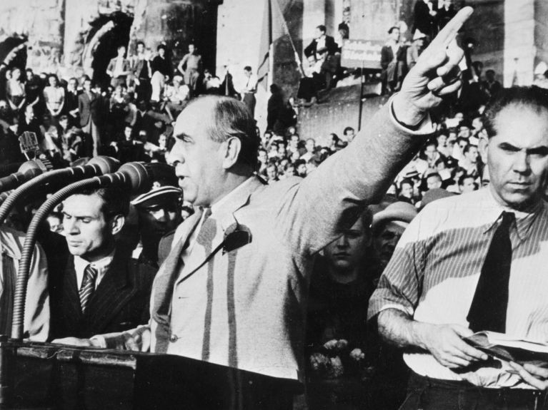 Ernst Reuter speaks in front of the ruins of the Reichstag.