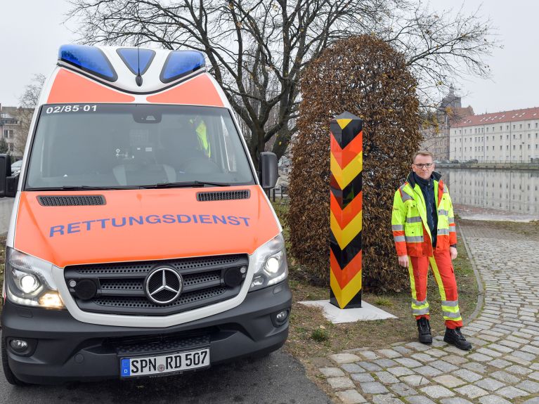 Ben Mangelsdorf von der Falck-Notfallrettung steht in Guben am Grenzfluss Neiße.