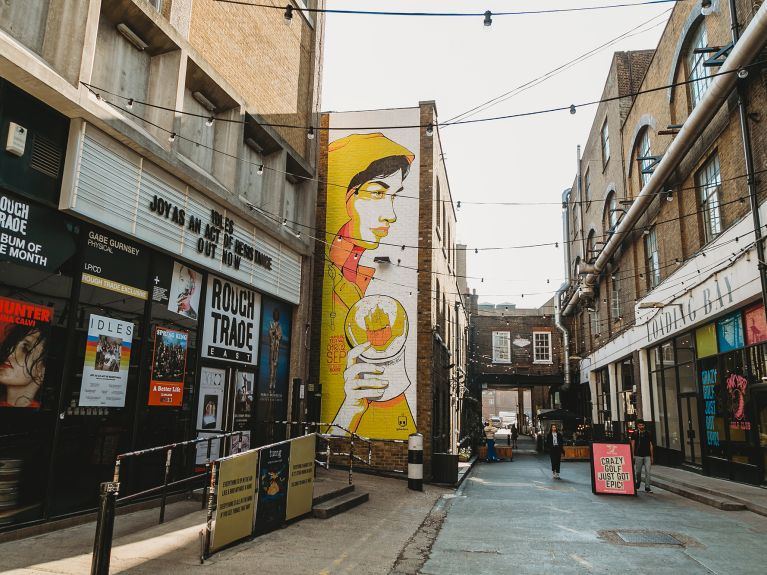 L’artiste de street-art Dawina a spécialement conçu cette figure féminine jaune avec l’Elbphilharmonie dans une boule à neige pour le festival dans la Bricklane à Londres.