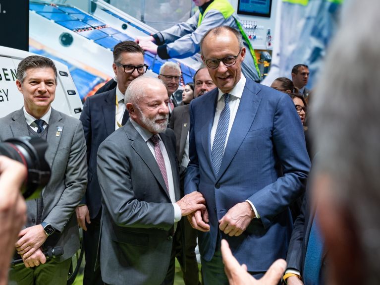 Mehrere Männer stehen an einem Messestand.