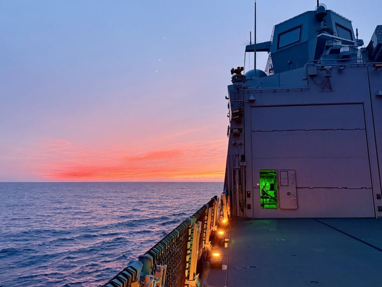View of a bright red sky from the deck of a ship 