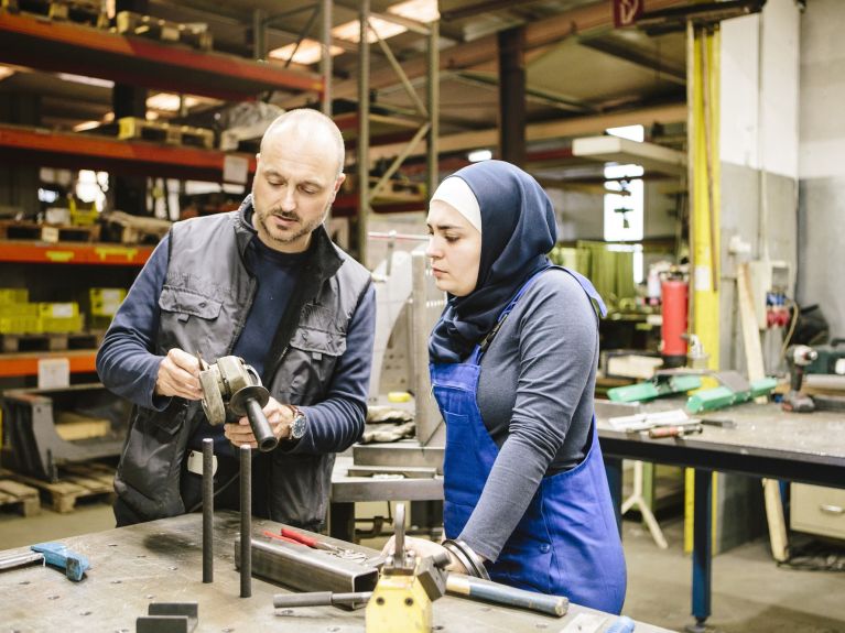 Un homme et une femme issus de la migration dans un atelier