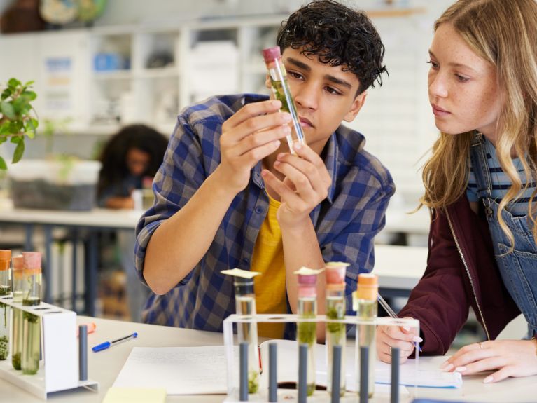 Zwei Studierende untersuchen ein Reagenzglas. Zwei Studierende untersuchen ein Reagenzglas.
