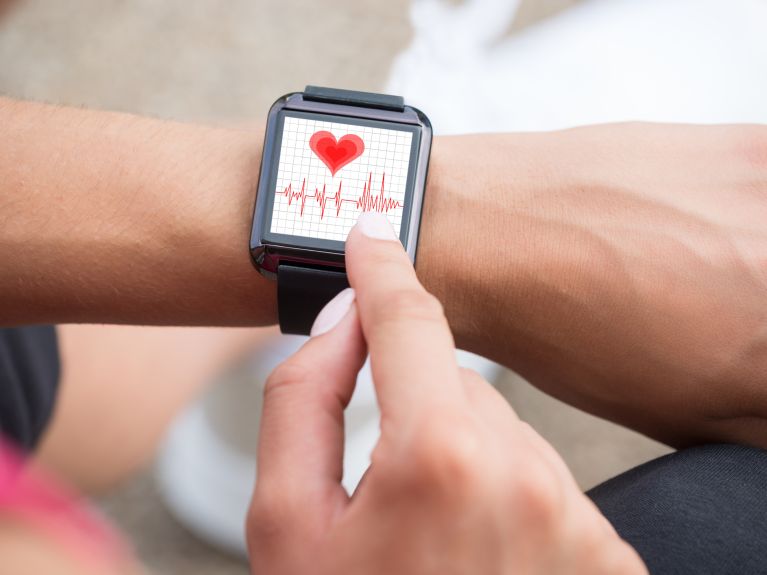 Hand mit Wearable und Gesundheits-App 