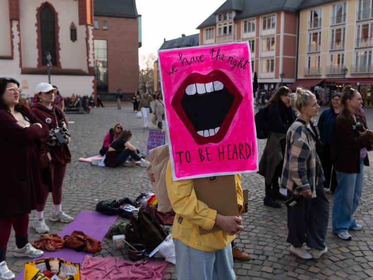 Mujeres jóvenes con pancartas en un mercado