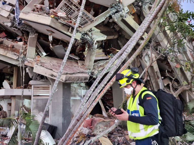 Un hombre pasa junto a un edificio destruido.