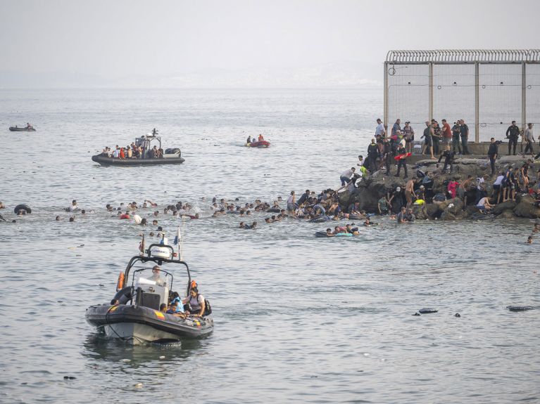 Menschen schwimmen über das Meer zu einem Felsen