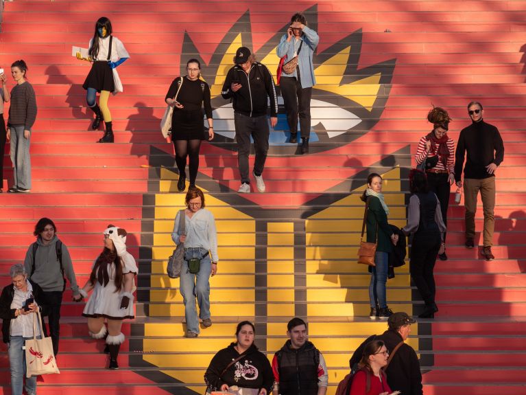 Visitors cross a red carpet featuring the Leipzig Book Fair logo. 