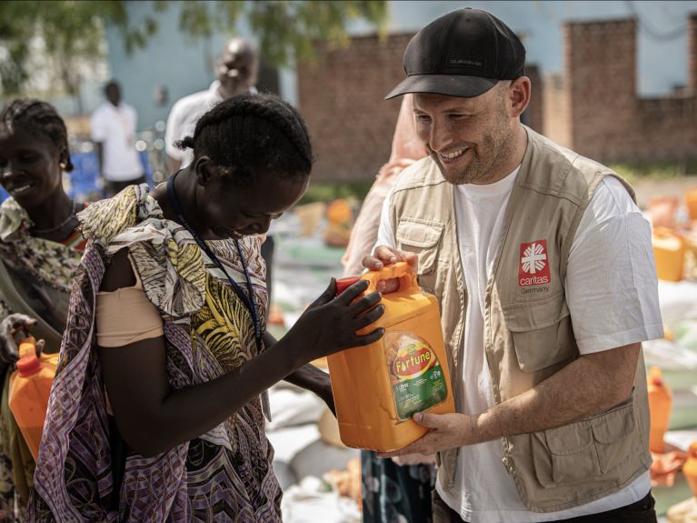 Kim Kerkhof überreicht einer Frau einen Kanister mit Öl in Kodok, Südsudan.       Kim Kerkhof überreicht einer Frau einen Kanister mit Öl in Kodok, Südsudan.