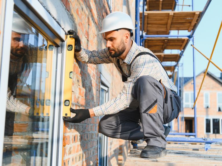 عامل بناء يتفقد تركيب النوافذ