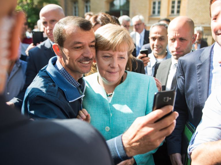 Kanzlerin Angela Merkel und ein Geflüchteter 2015