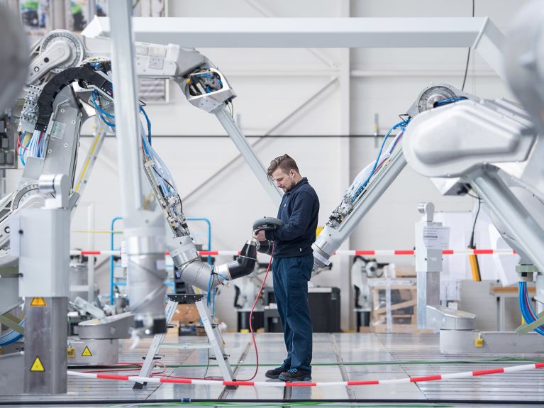Pracownik firmy Dürr AG testuje robota lakierniczego.