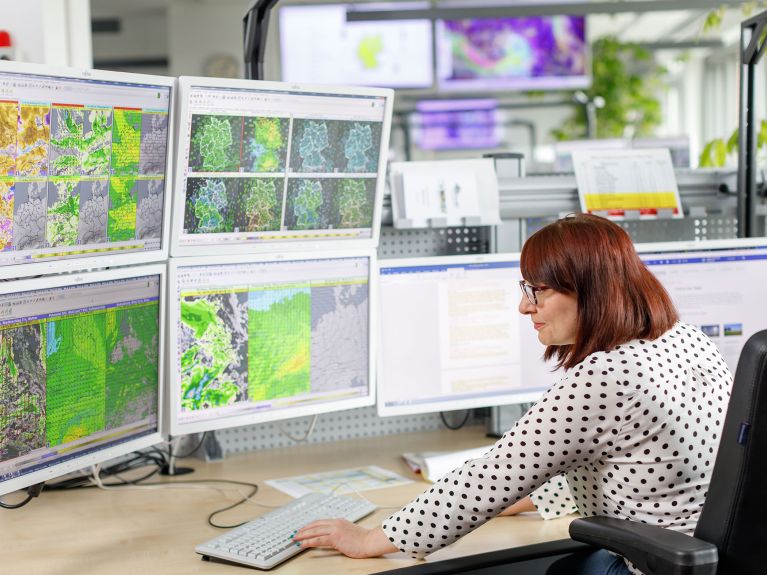 A meteorologist analyses weather data and forecasting models.