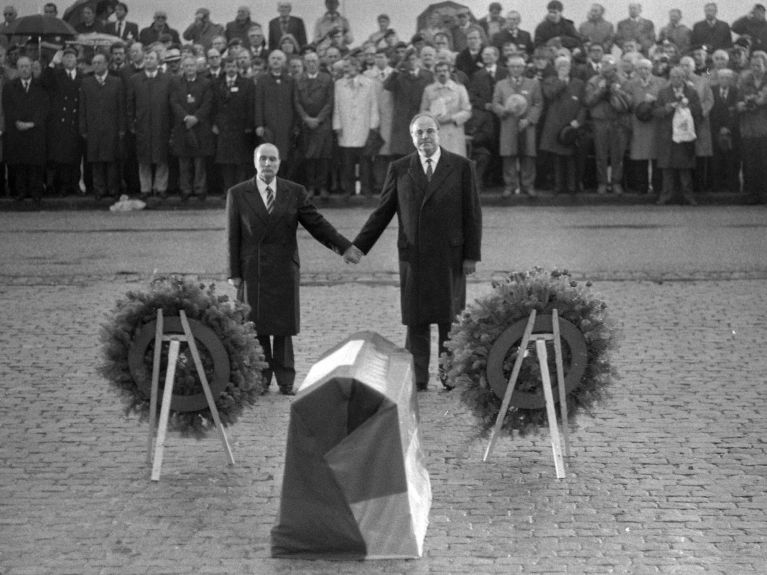 1984年：法国总统François Mitterrand和联邦总理Helmut Kohl在凡尔登古战场上携手纪念法国和德国的二战受害者。