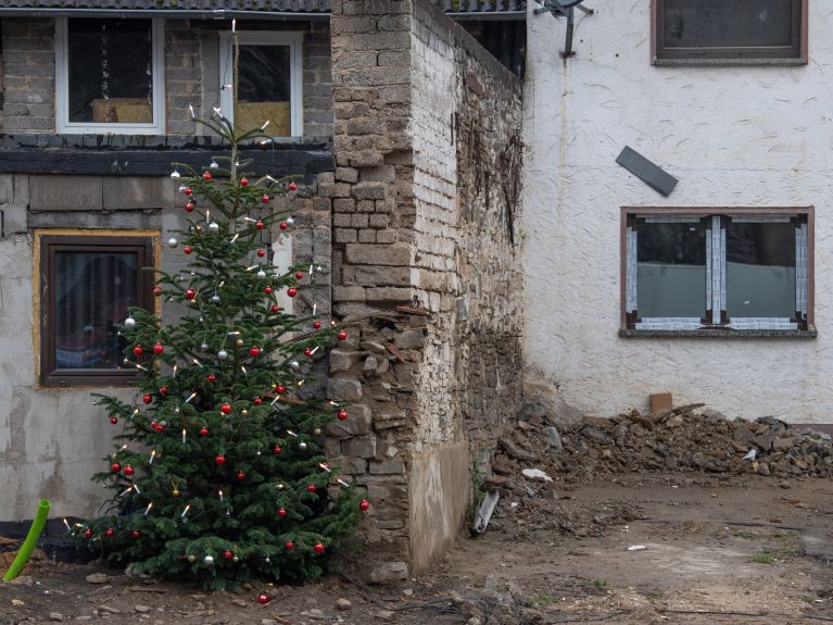 Ein Weihnachtsbaum an einem beschädigten Haus im Ahrtal