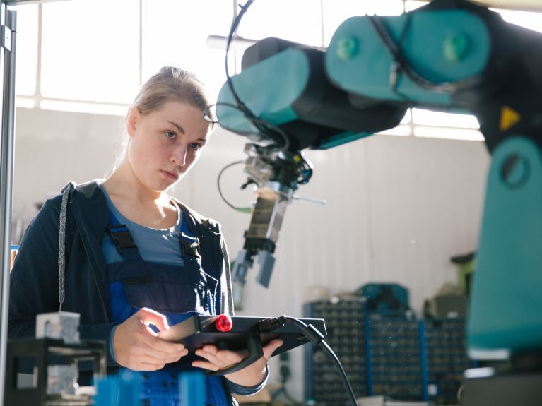 Una mujer controla un robot.