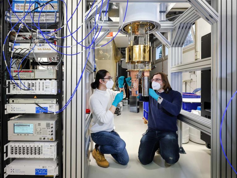 كومبيوتر كمومي فيزيائيون في مركز أبحاث يوليش، يعملون في مختبر كمومي على ابتكار ناظم كريوستات 
