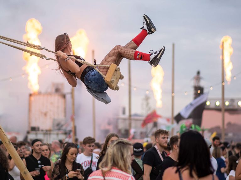 Посетительница фестиваля электронной музыки Parookaville качается на качелях. 