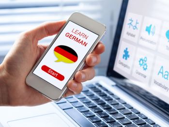 Hand mit Handy und Deutsch-App Hand mit Handy und Deutsch-App